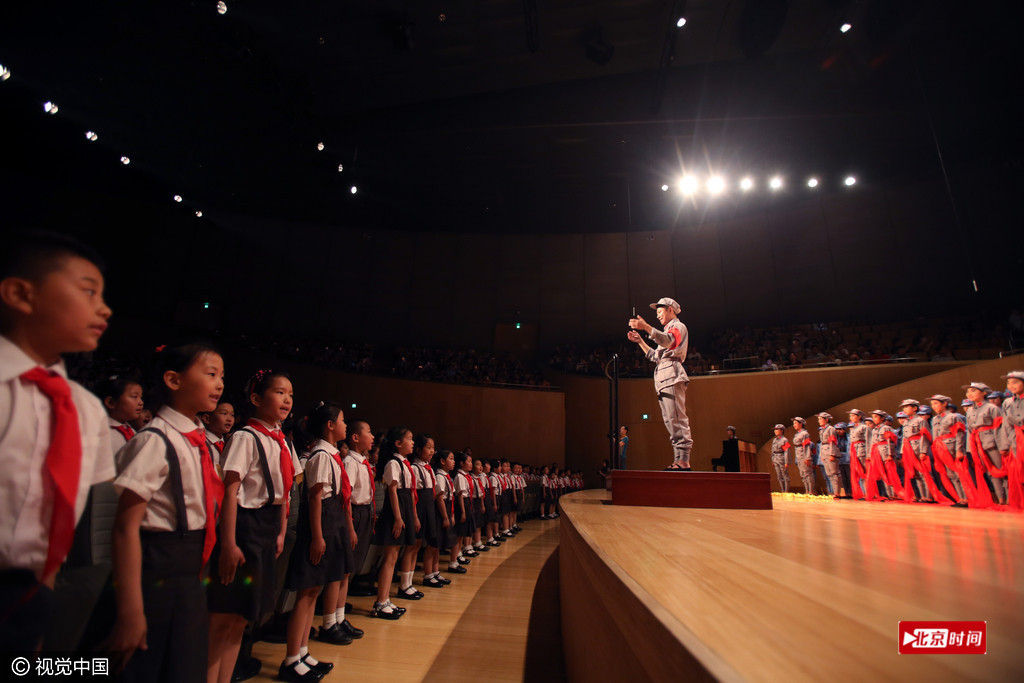 学生们在指挥的带领下合唱红歌.